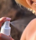 getty rf photo of woman using sunscreen spray