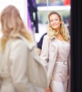 woman looking in mirror trying clothes